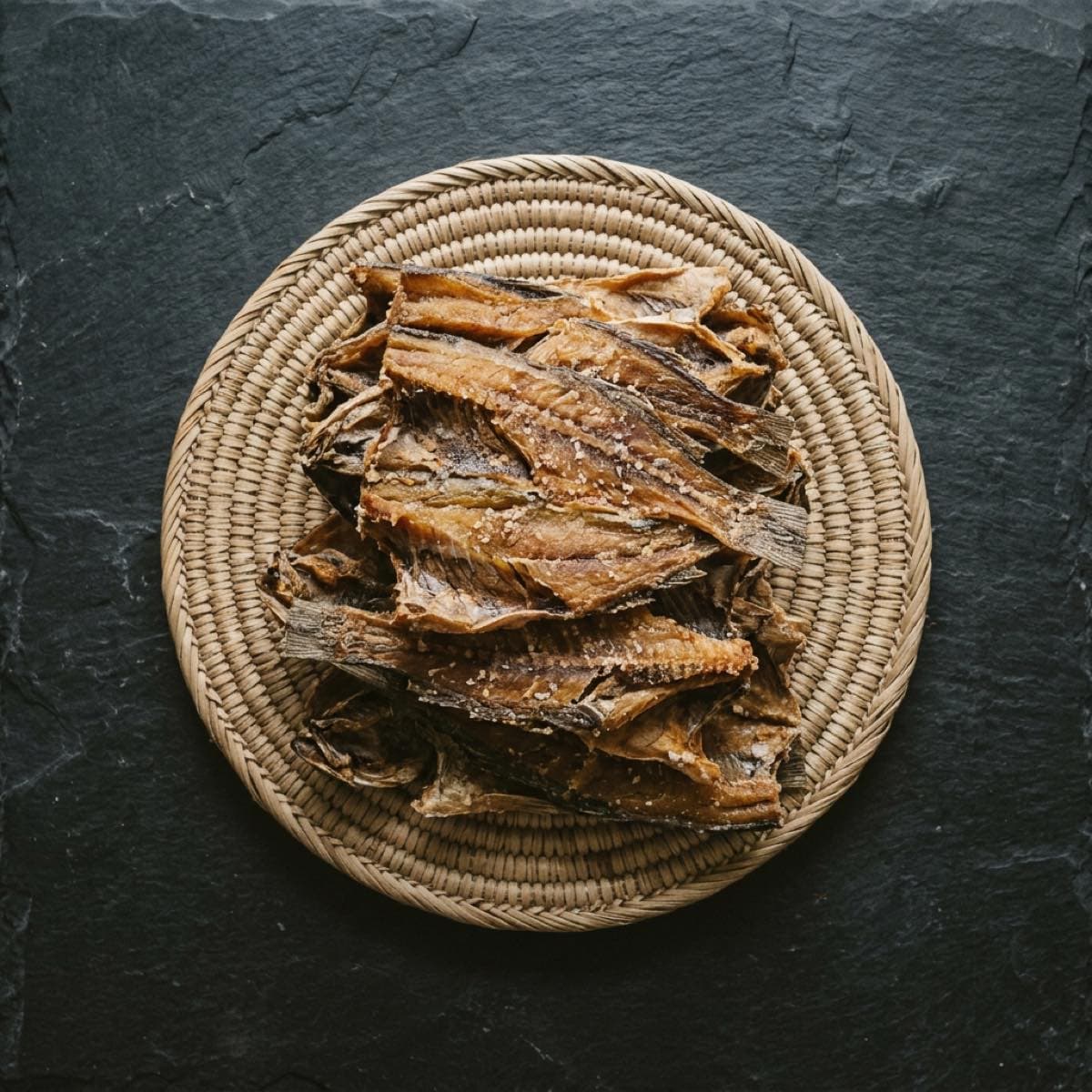 Morceaux de poisson-chat salé-séché sur un plateau tressé